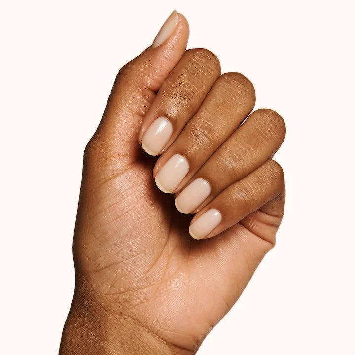Hand with glossy sheer polish on natural nails showcasing Nourishing Nails System for at-home manicure care