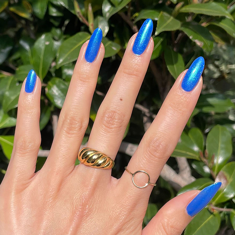 Blue For You Set showcasing glossy cobalt blue manicure with iridescent chrome finish on natural hand outdoors
