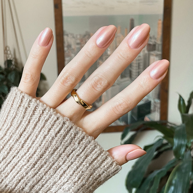Hand with medium oval nails polished in Olive and June Cookie Swap gel polish wearing gold ring indoors