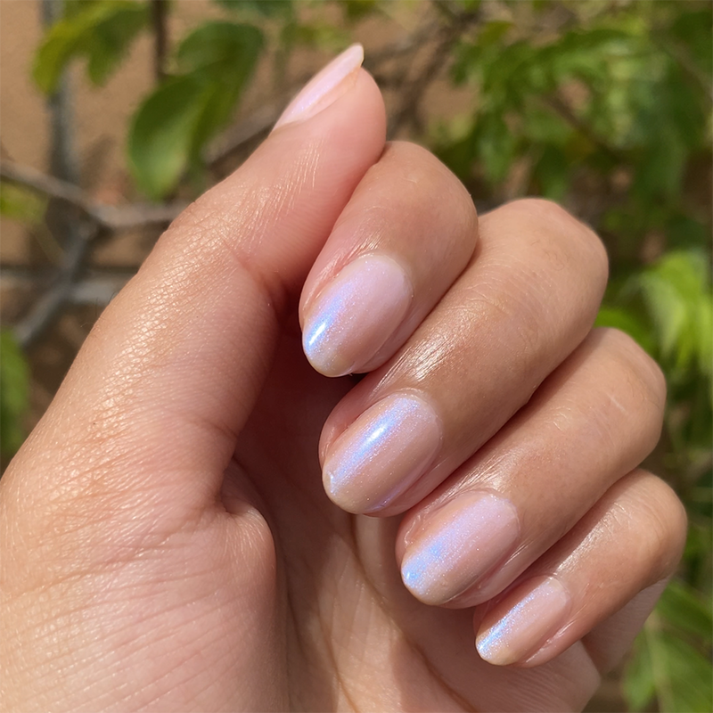 Natural hand with pearlescent pink manicure created using The Glazed Mani System polish for at-home nails.
