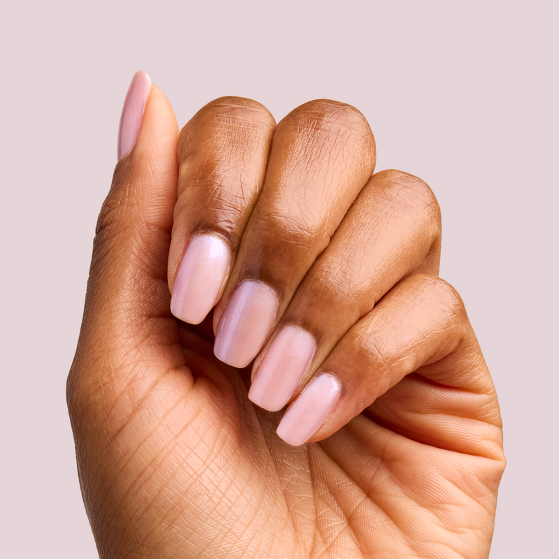 Hand with nails painted in soft pearly pink using BAROQUE Gel for a delicate at-home manicure look