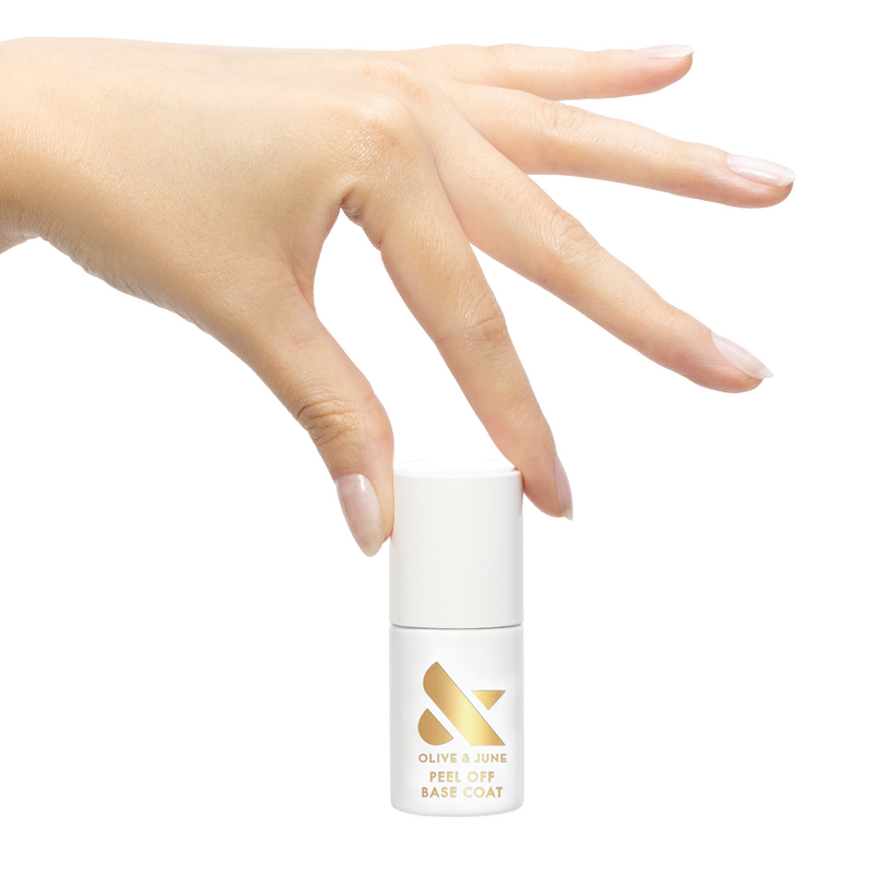 Hand holding Olive and June Peel Off Base Coat bottle with natural nails for easy at home gel manicure removal