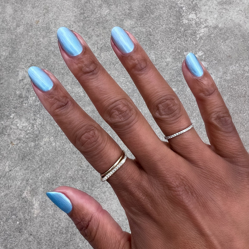 Same Day Next Year sheer shimmery blue polish on natural nails with a smooth finish for an easy at-home manicure