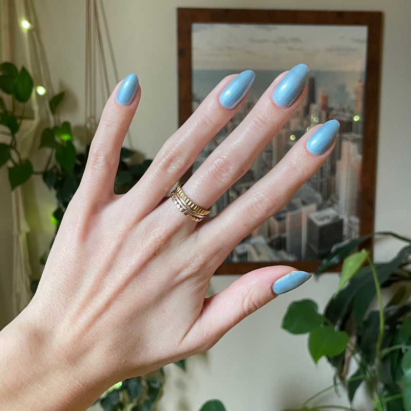 Same Day Next Year sheer blue polish on medium-length nails with a smooth, glossy finish for an easy at-home manicure