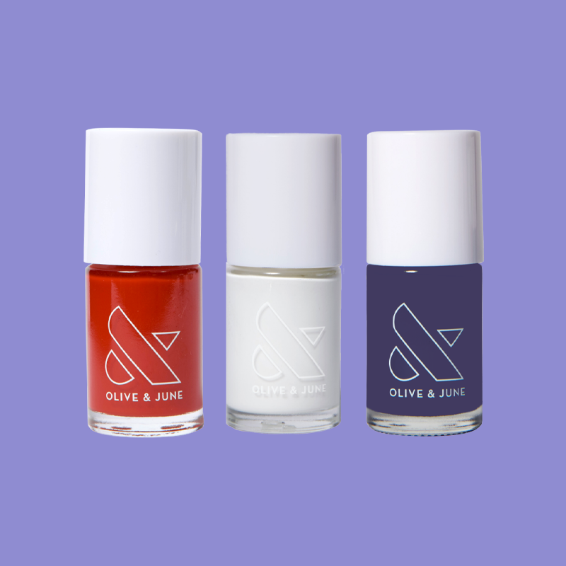Festive Flag Set showing cherry red, crisp white, and deep indigo Blue nail polish bottles on purple background