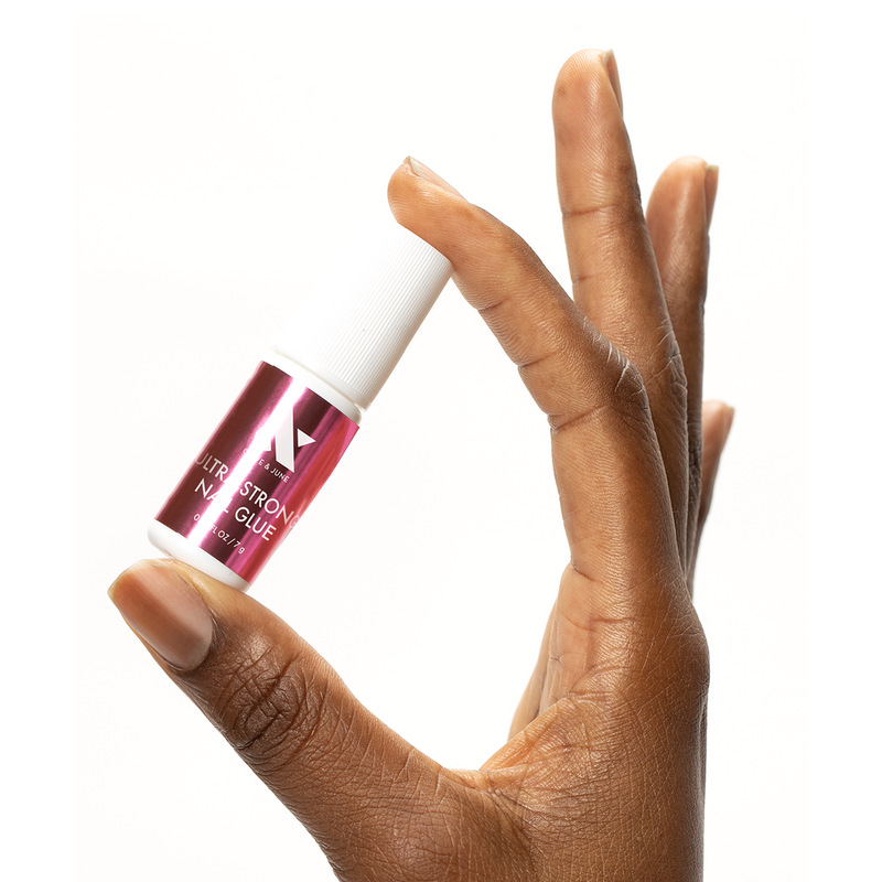 Hand holding a bottle of Ultra Strong Nail Glue for long-lasting press-on nails and precise at-home manicures