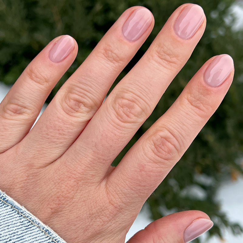 Hand with nails polished in soft neutral mauve using The Queen Takes her Tea with Milk for a gentle gel manicure