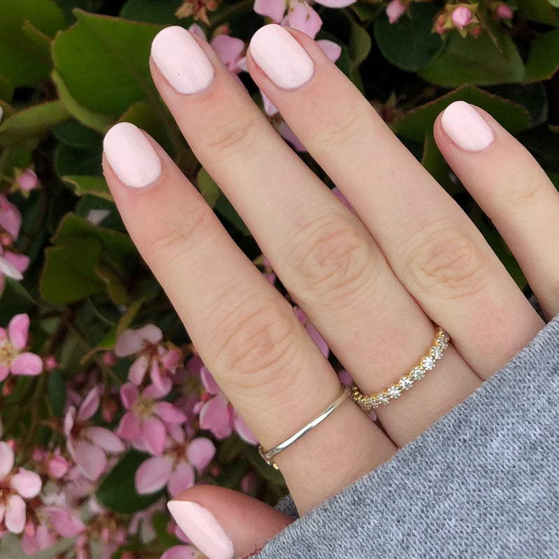 Hand with nails coated in GH, a soft opaque baby pink polish ideal for an elegant and versatile at-home manicure