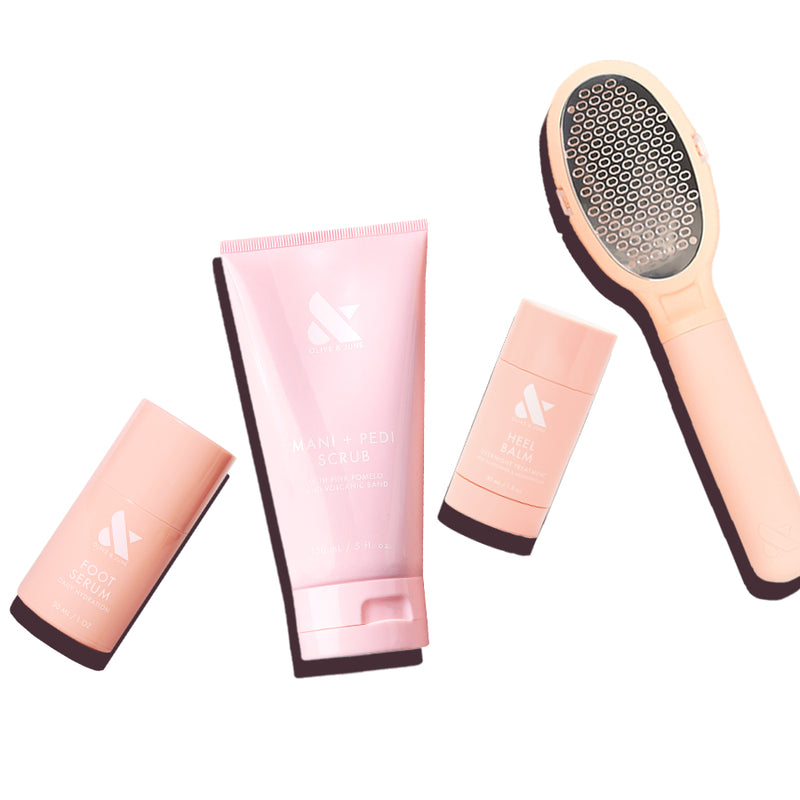 Foot Care Essentials Set with foot serum, mani + pedi scrub, heel balm, and foot file in soft pink packaging