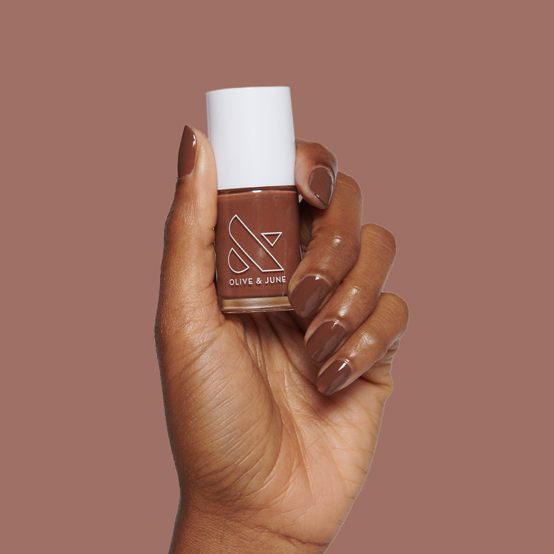 Tip Your Barista | Dark brown long-lasting nail polish bottle held by hand with matching polished nails