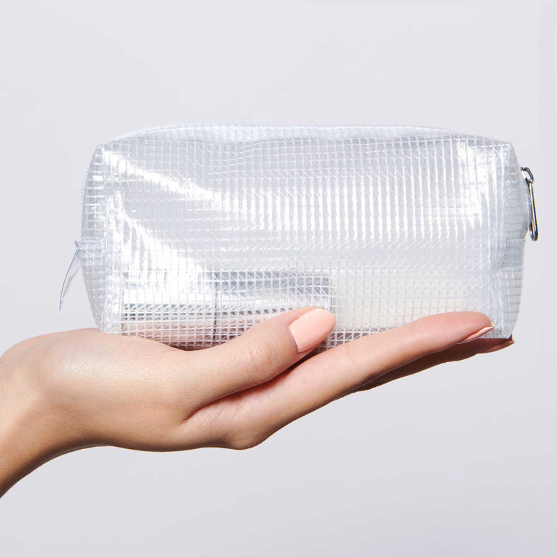 Hand holding The K.I.T. Kit clear pouch containing nail care essentials for mani and polish protection by Olive and June