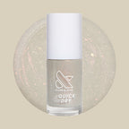 Bottle of Moonlit quick dry gel polish with milky sheer grey base and subtle holographic flakes on beige background