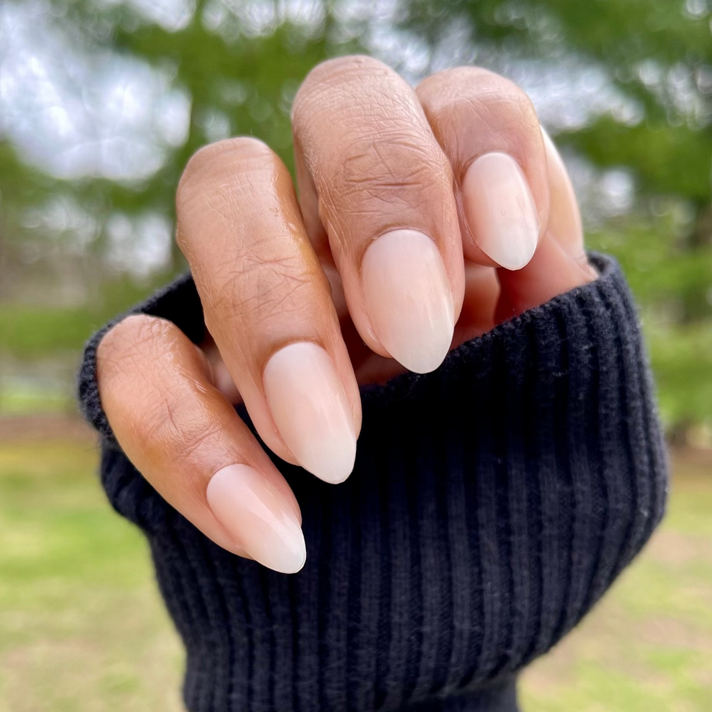 Milky Syrup Gradient - Press-On | Medium | Almond showing hand with medium almond false nails in soft milky white gradient polish outdoors