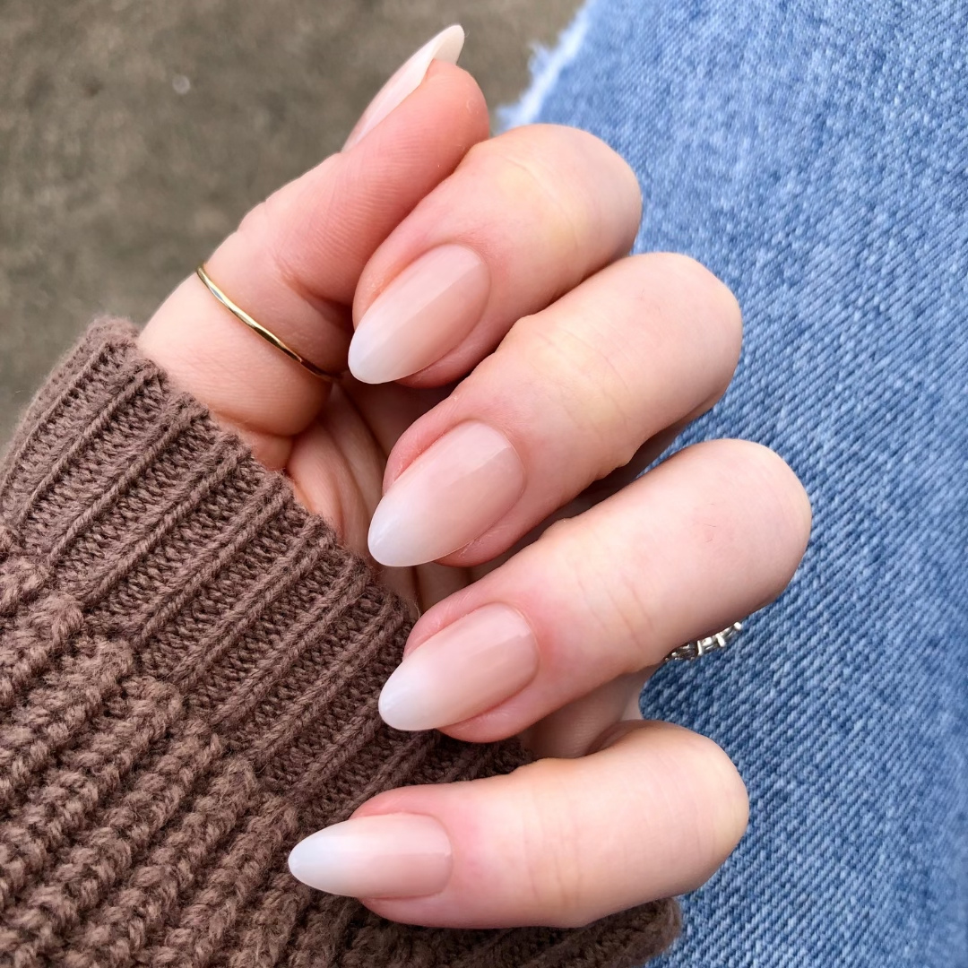 Milky Syrup Gradient - Press-On | Medium | Almond showing hand with medium almond false nails in soft milky white gradient polish indoors