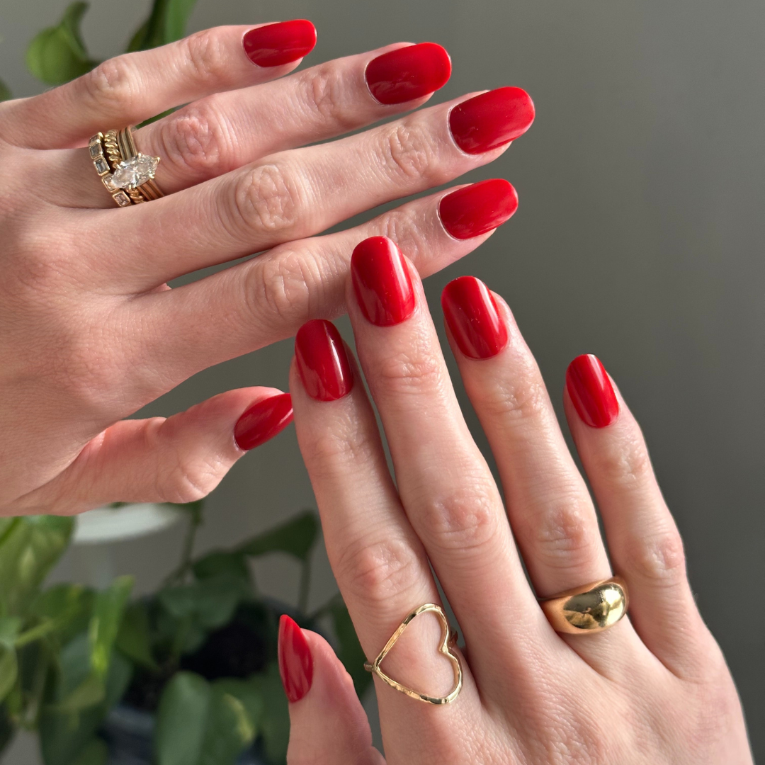 Hands wearing bright red Ally Rooker Super Stick Set nails showing glossy long-lasting press-on manicure design