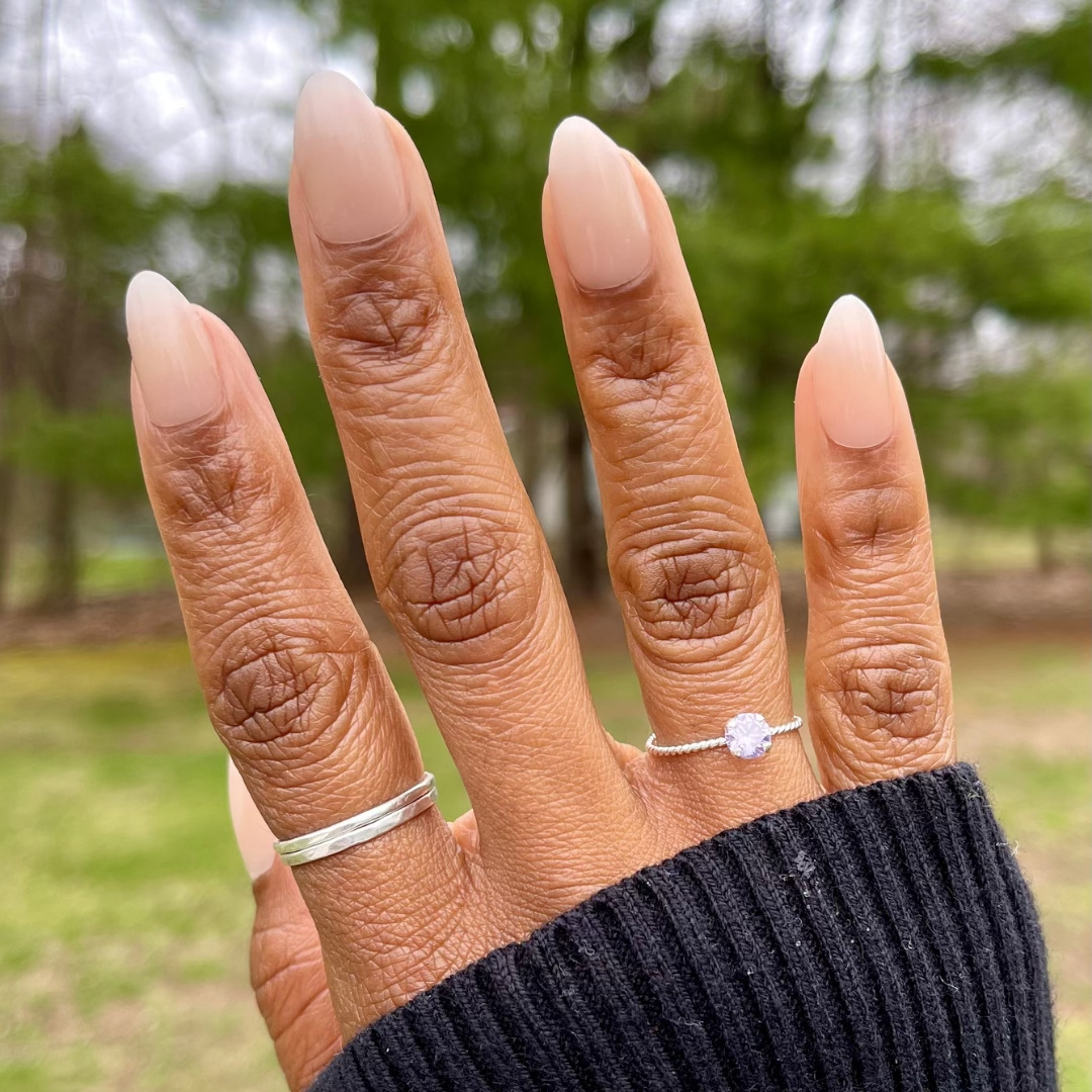 Milky Syrup Gradient - Press-On | Medium | Almond showing hand with medium almond false nails in soft milky white gradient outdoors