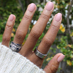 Poodle | Extra Short | Squoval - Tab Press-On nails in soft neutral beigey pink on hand with silver rings outdoors