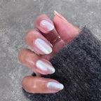 Hand with medium-length natural nails painted in shimmering Midnight Disco polish against gray background