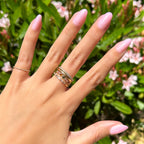 Iridescent Pink - Press-On | Medium | Oval showing hand with medium oval false nails in soft pink iridescent finish outdoors with greenery background