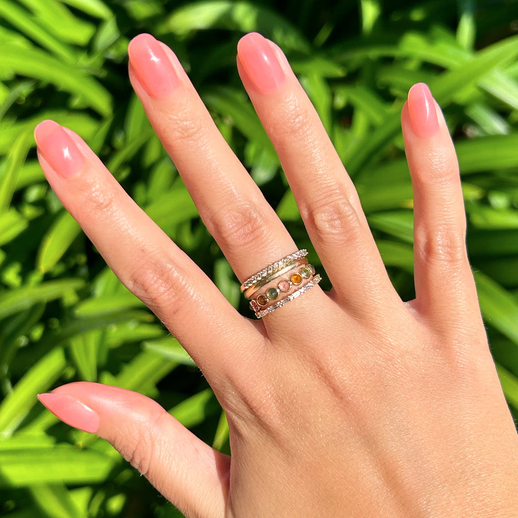 Pink Jelly - Press-On | Short | Round showing hand with sheer pink jelly press-on mani and gold rings outdoors
