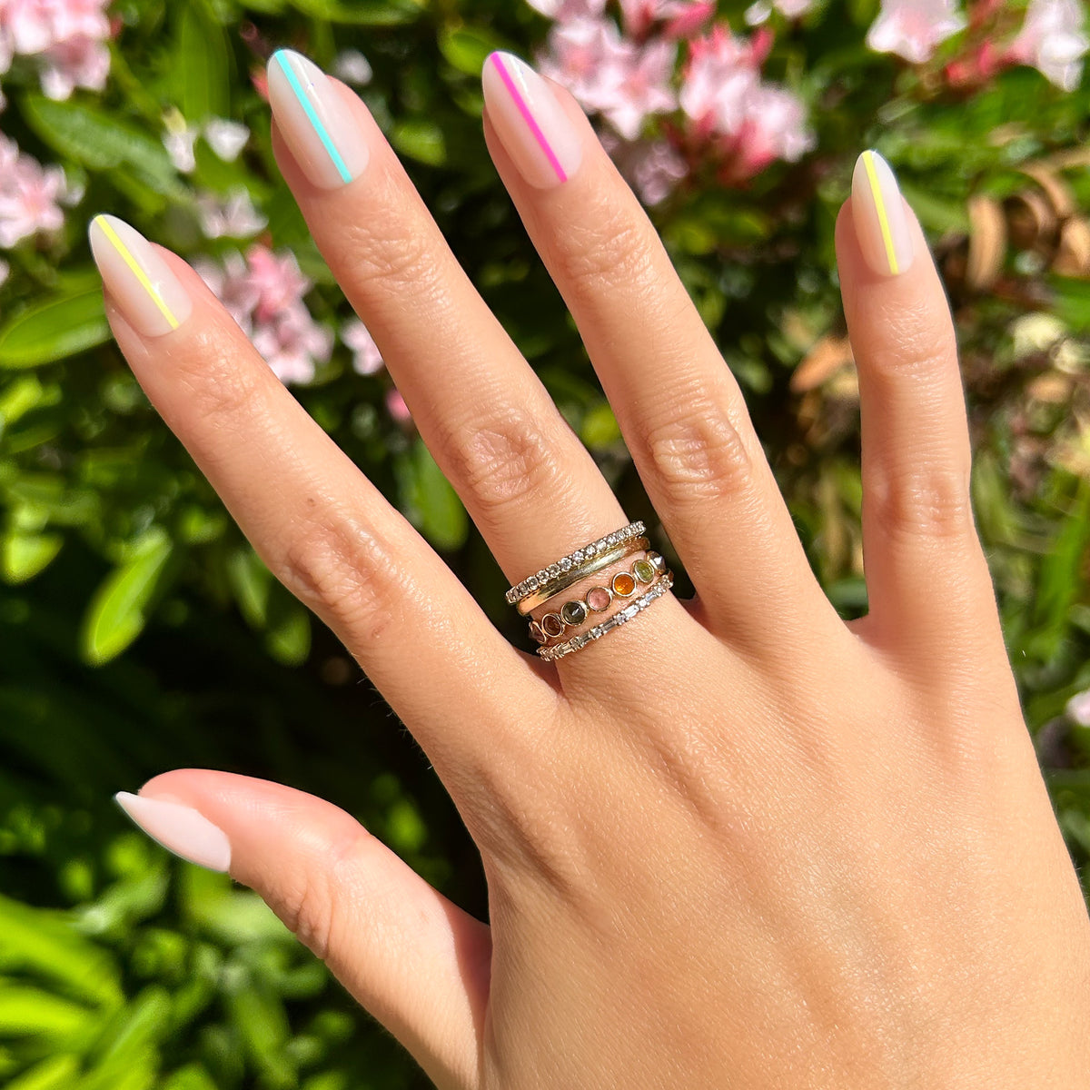 Neon Lines - Press-On | Medium | Almond showing hand with medium almond press-on nails featuring neon vertical stripes outdoors in sunlight