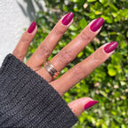 Hand wearing glossy Cabernet polish in rich plummy wine red for a polished, sophisticated at-home manicure look