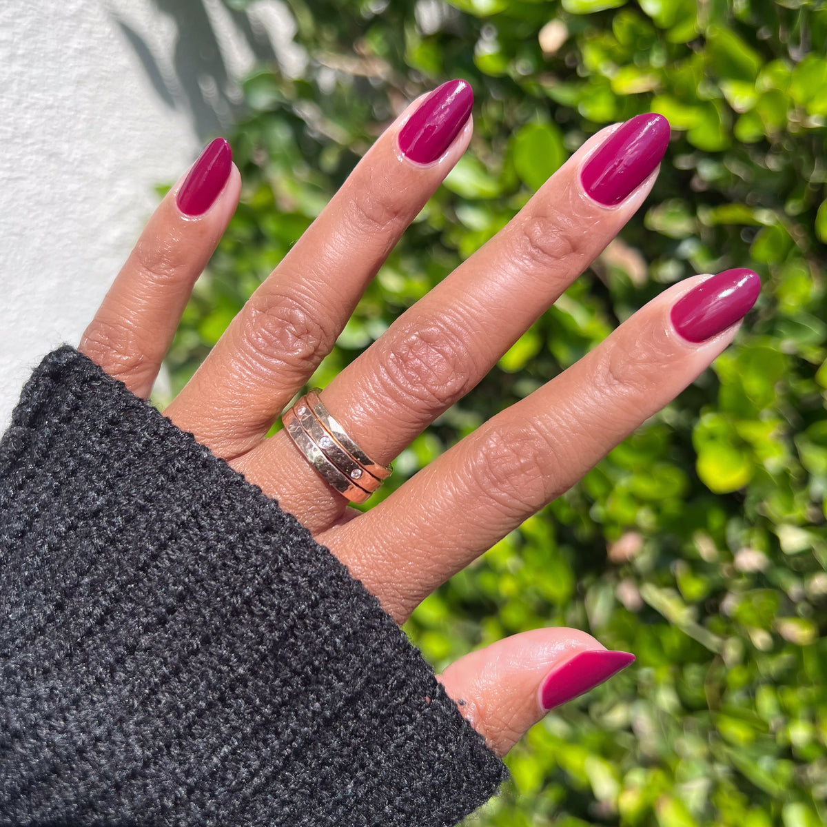 Hand wearing glossy Cabernet polish in rich plummy wine red for a polished, sophisticated at-home manicure look