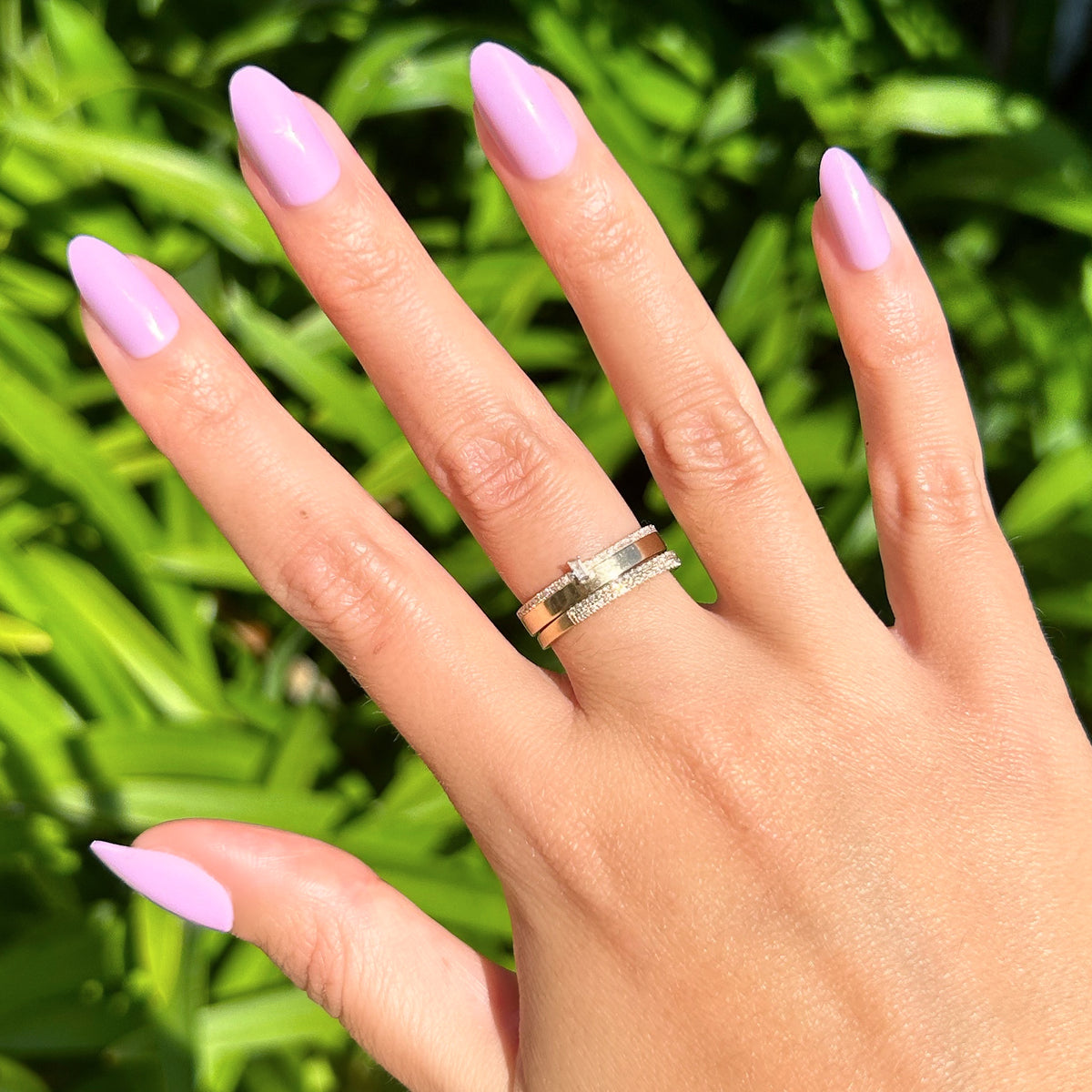 You're Invited - Press-On | Medium | Almond showing hand with lilac purple almond press-on manicure outdoors with silver rings