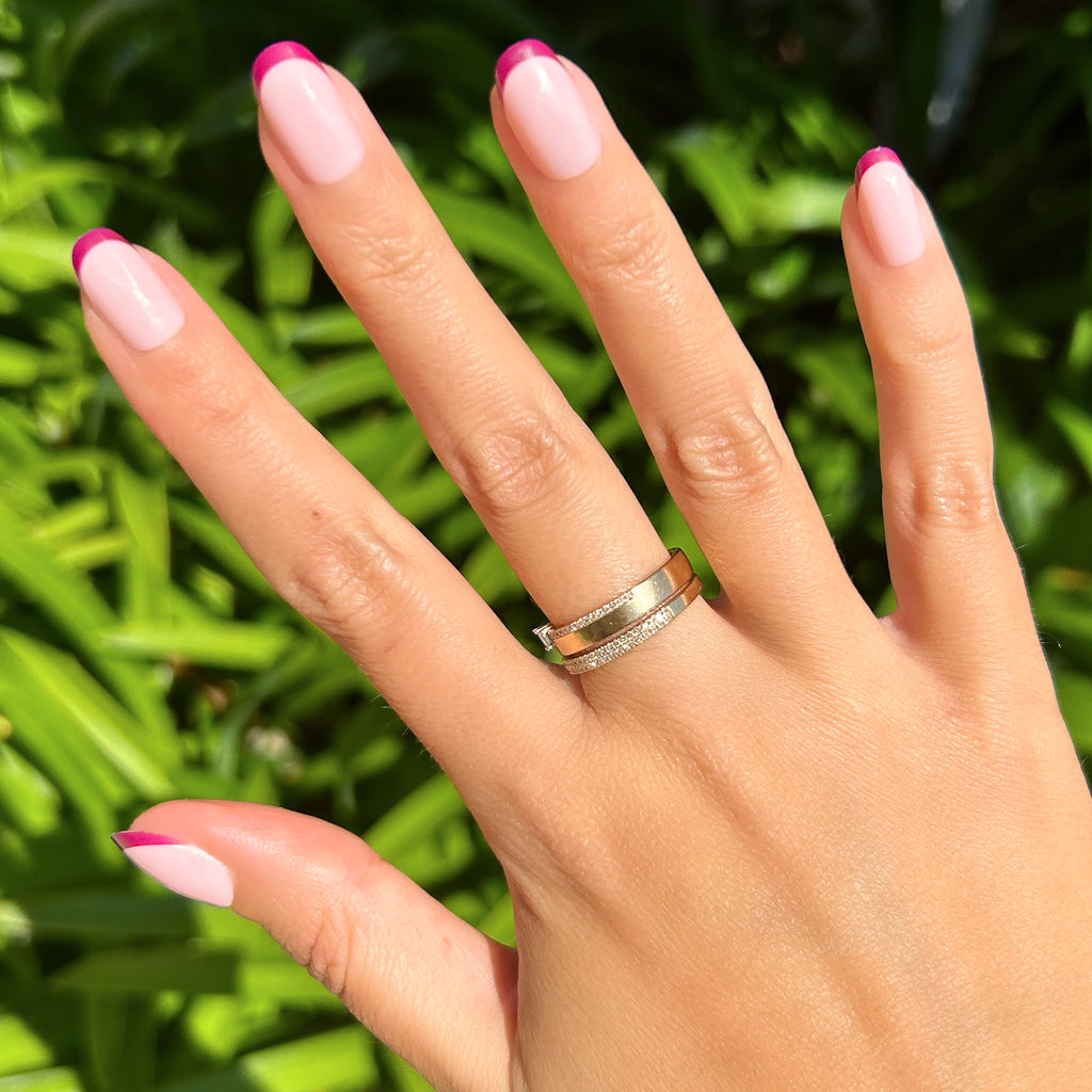 Plum Tonal French - Press-On | Short | Round showing hand with short round false nails featuring plum tips outdoors with greenery background