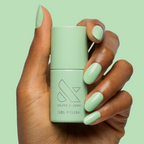Hand holding Aced It - Gel bottle with nails painted in a soft pastel green for a fresh mani look