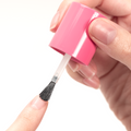 Hand applying Advanced Nail Strengthener with brush to natural fingernail for durable nail growth and protection. thumbnail