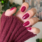 Hand wearing Cabernet gel polish in deep plummy wine red for a rich, polished at-home manicure look