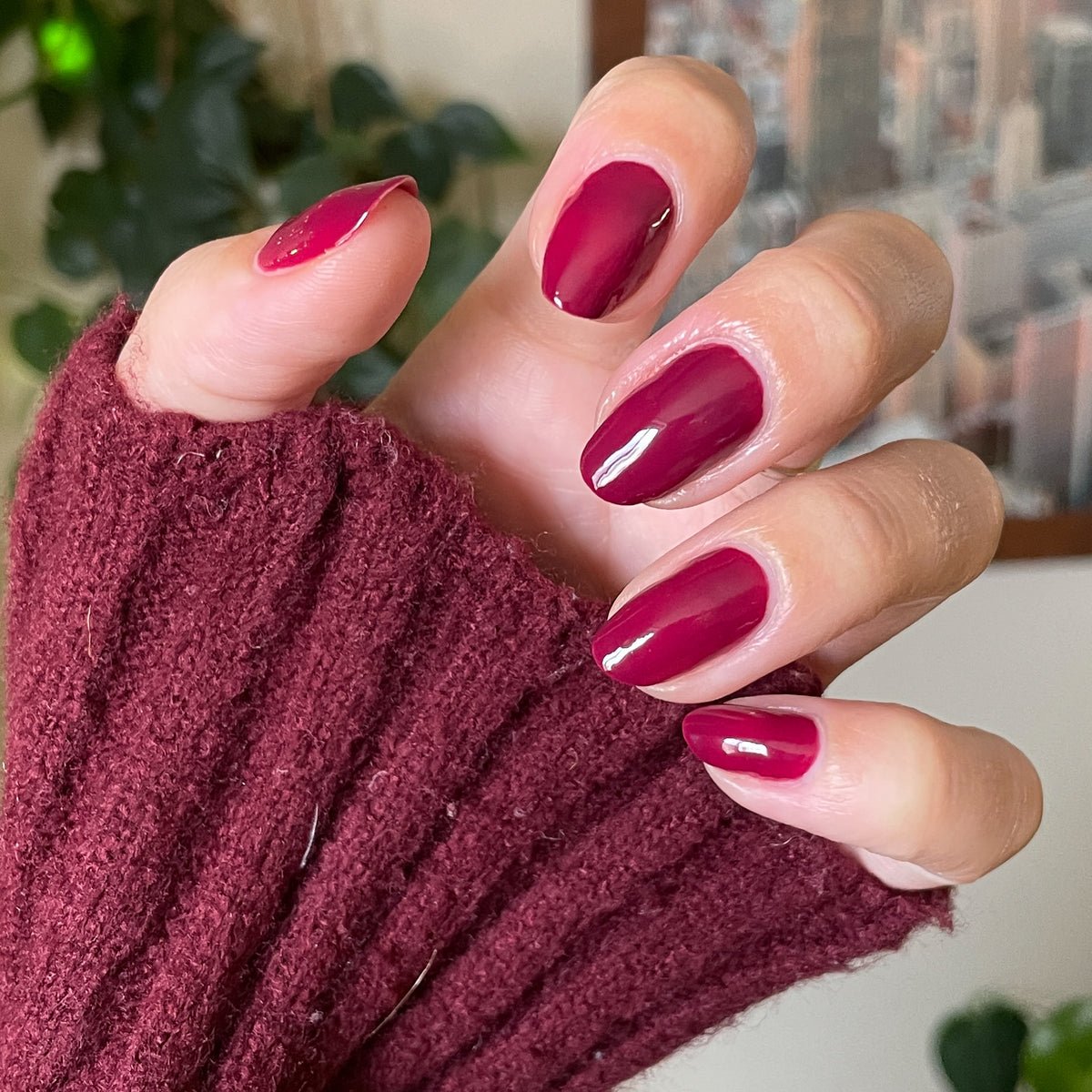 Hand wearing Cabernet gel polish in deep plummy wine red for a rich, polished at-home manicure look