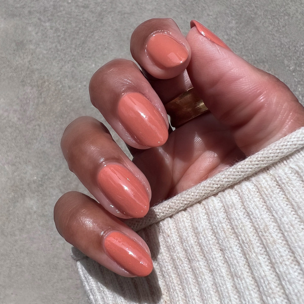 Hand with smooth Canyon gel polish in warm desert orange shade for natural and long-lasting at home mani options
