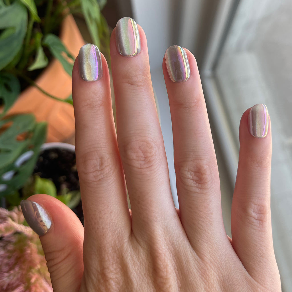 Sheer Lavender Shimmer - Press-On | Extra Short | Round showing hand with iridescent lavender shimmer press-on mani indoors near plants