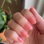 Pink Jelly - Press-On | Short | Round showing close-up of sheer pink jelly press-on manicure on natural nails indoors