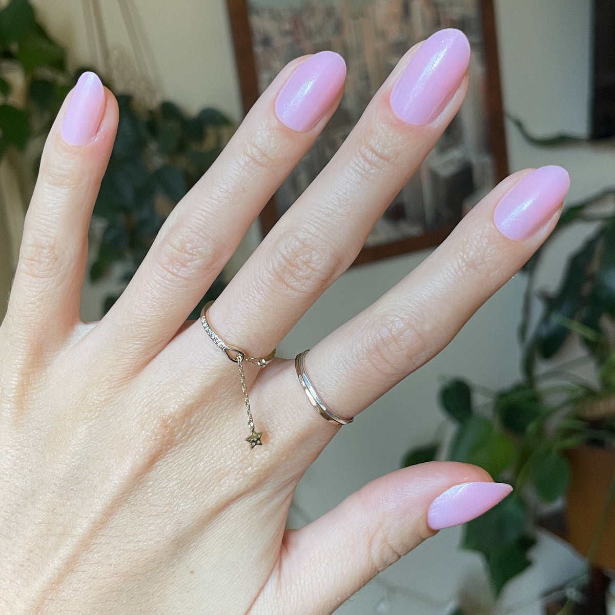 Iridescent Pink - Press-On | Medium | Oval showing hand with medium oval false nails in soft pink shimmer indoors