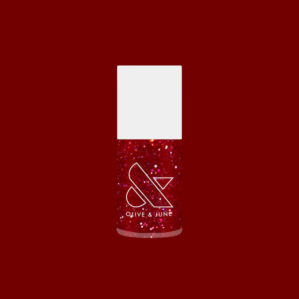 Bottle of Splash of Cran quick dry gel polish in bubbly shimmery pinky-red with glitter on deep red background