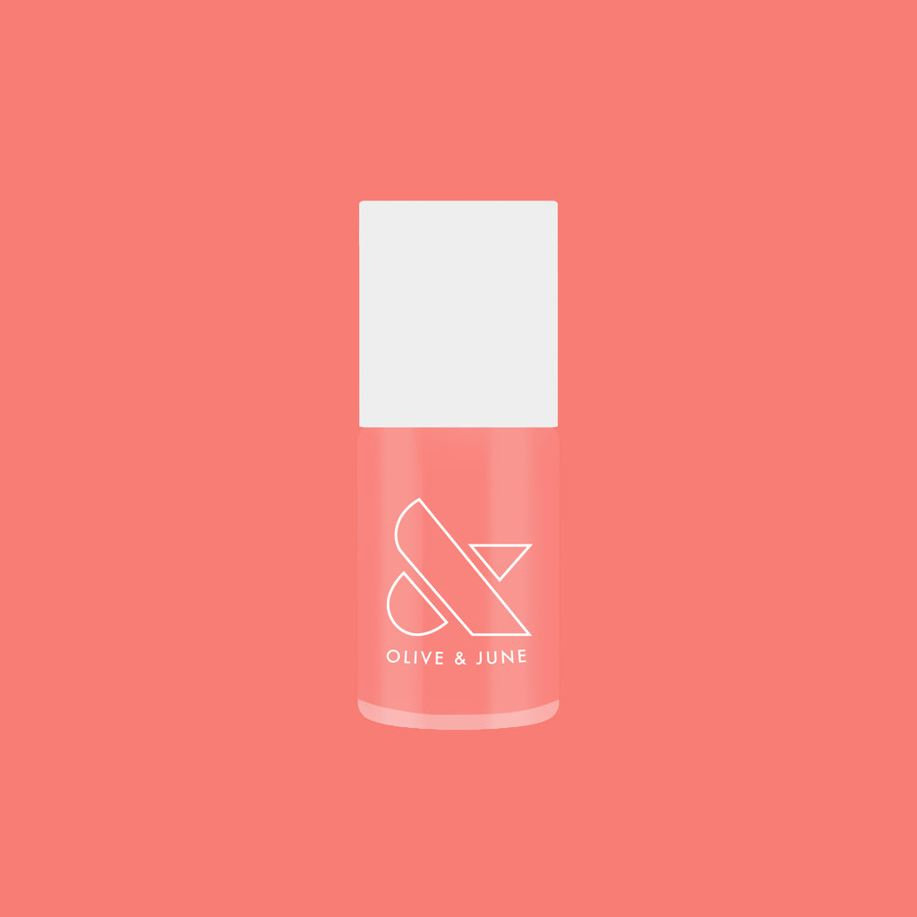 Olive and June Papaya Gloss sheer coral pink nail polish bottle against matching coral background for mani or pedicure