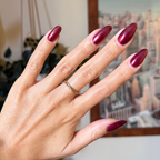 Budget? What Budget Gel deep rose-orange duochrome gel polish on almond-shaped nails for a sleek manicure by Olive and June