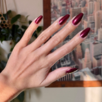 Budget? What Budget deep rose-orange duochrome polish on almond-shaped nails for a sleek manicure look