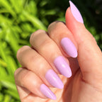 You're Invited - Press-On | Medium | Almond showing hand with playful lilac medium almond press-on manicure outdoors in natural light
