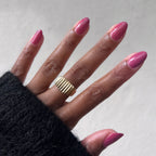 Hand with Primrose gel polish in warm rosey pink showing a smooth manicure and gold ring on medium skin tone