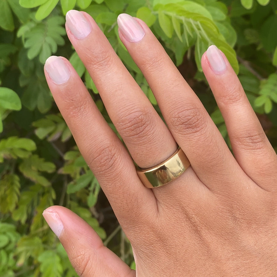 Hand with warm skin tone nails painted in soft iridescent Elevator quick dry polish for a natural at home manicure