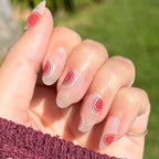 Layered Circles - Press-On | Medium | Oval nails with neutral base and burnt orange circle accents in natural light outdoors