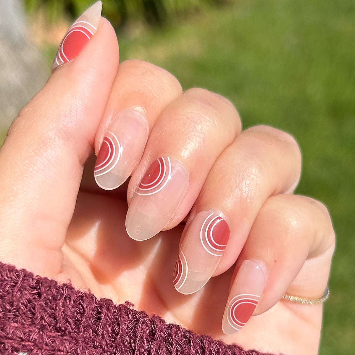Layered Circles - Press-On | Medium | Oval nails with neutral base and burnt orange circle accents in natural light outdoors