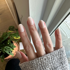 Classic French | Short | Round - Tab Press-On nails with soft white tips shown on hand wearing cozy sweater near window light