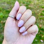 Floral Tip | Short | Round - Tab Press-On nails with neutral base and soft lavender floral accents on hand outdoors