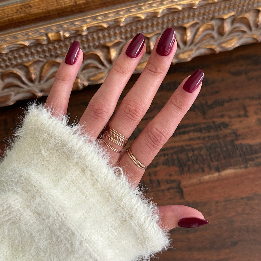 Cabernet | Medium | Oval - Tab Press-On showing glossy medium oval dark plummy red press-on nails for easy at home manicure