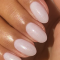 The Celestial Effect Top Coat on natural nails with a soft white base and fine shimmering micro-shimmer for a radiant mani thumbnail